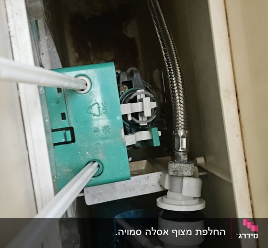 תמונה של פנים מיכל שירותים עם צינורות וחיבורים
